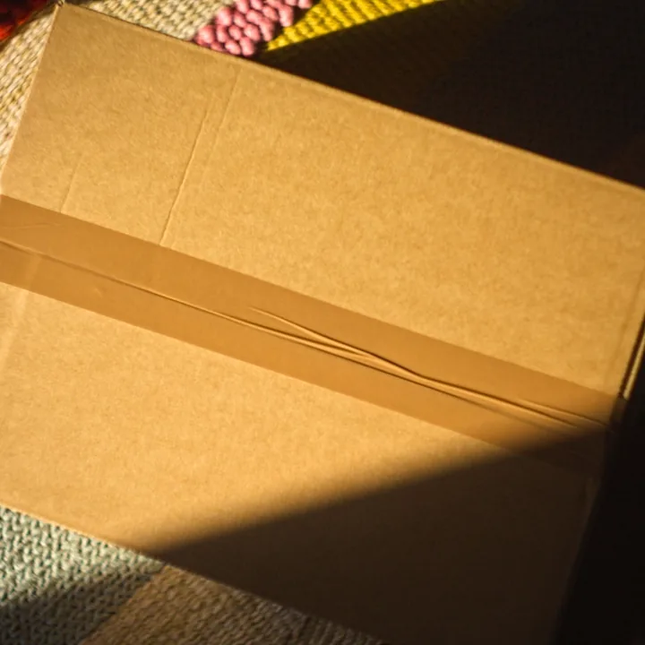 A plain kraft shipping box, taped and ready to go back