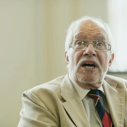 An older man mid-sentence, speaking to camera
