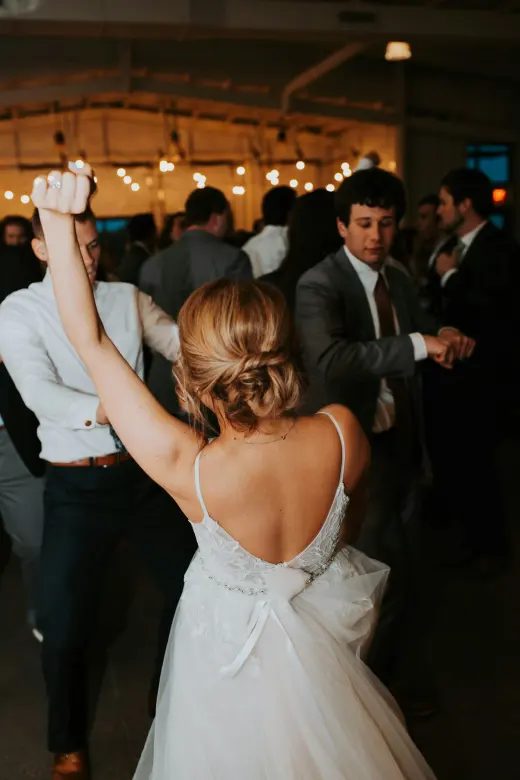 A bride dancing with guests on the reception floor