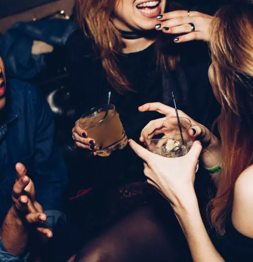 Friends laughing together holding cocktails