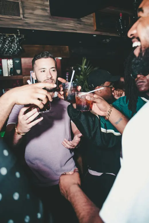 Friends laughing together with drinks in hand