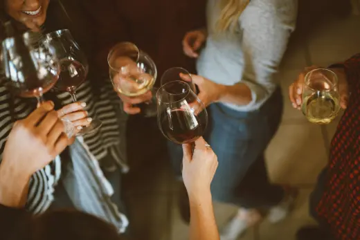 Guests clinking wine glasses over a table