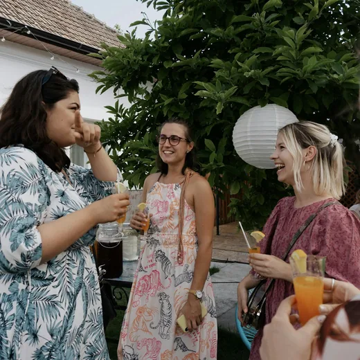 Guests laughing with drinks in hand at a garden party