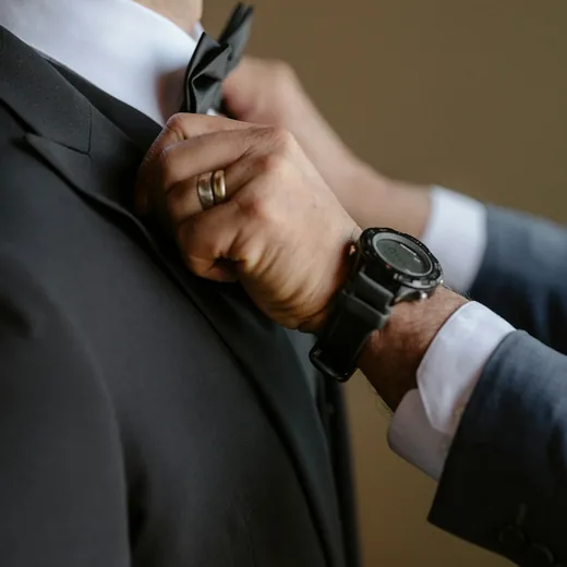Hands adjusting a tie before the ceremony