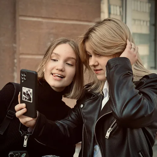 Two teenagers filming themselves on a phone