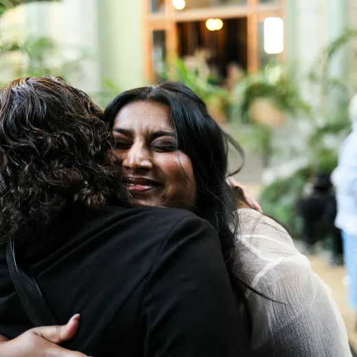 Two women embracing as guests arrive